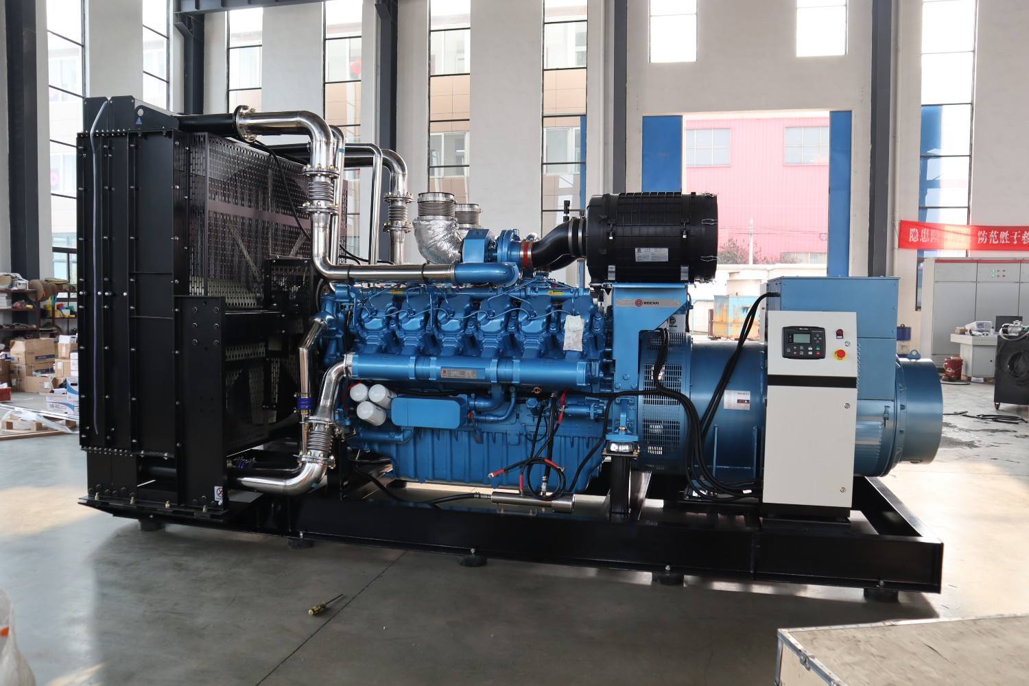 Large diesel generator set with sixteen cylinder engine installed on a steel skid in a workshop